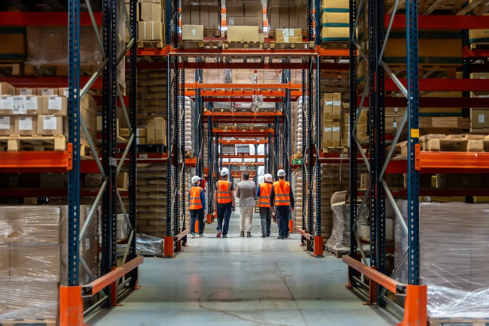 Warehouse with rack rows and staff walking the aisle